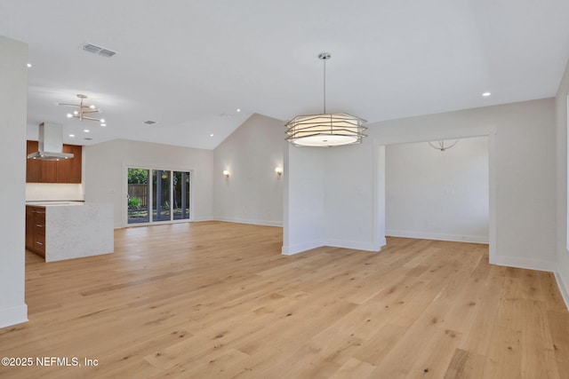 unfurnished living room with lofted ceiling and light hardwood / wood-style flooring