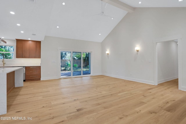 unfurnished living room featuring light hardwood / wood-style flooring, high vaulted ceiling, and plenty of natural light