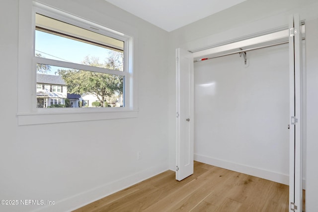 unfurnished bedroom featuring light hardwood / wood-style floors and a closet