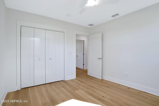 unfurnished bedroom with light hardwood / wood-style floors, a closet, and ceiling fan