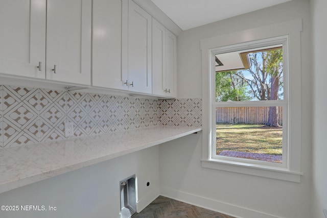 laundry room featuring cabinets, dark parquet floors, and electric dryer hookup