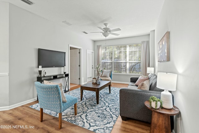 living room featuring ceiling fan, a textured ceiling, and light hardwood / wood-style floors