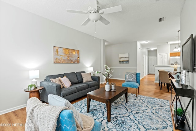 living room with ceiling fan and light wood-type flooring