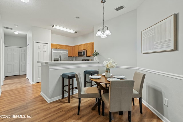 dining room featuring a chandelier and light wood-type flooring