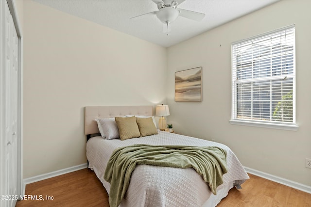 bedroom with hardwood / wood-style flooring, ceiling fan, and a closet