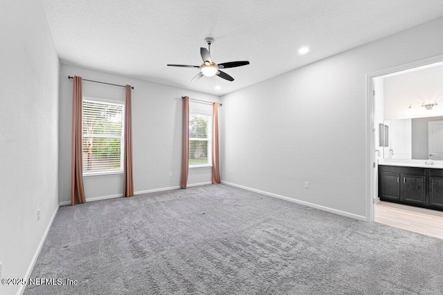 carpeted spare room with a textured ceiling and ceiling fan