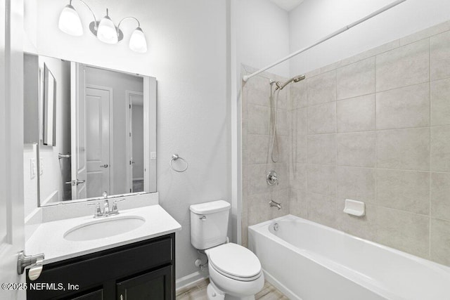 full bathroom featuring tiled shower / bath, vanity, and toilet