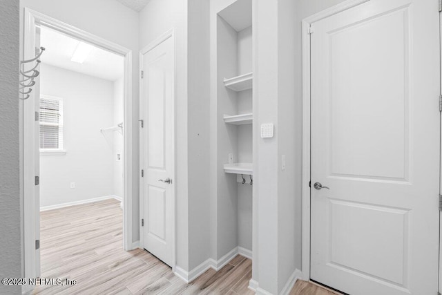 hallway with light hardwood / wood-style floors