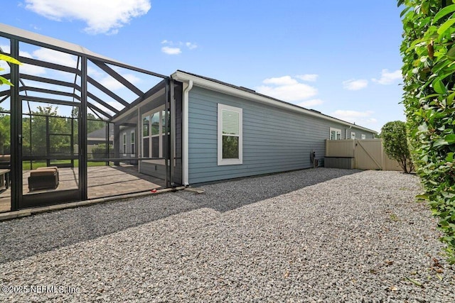 view of side of property featuring a lanai and a patio