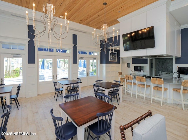 dining space with french doors, sink, wood ceiling, ornamental molding, and a notable chandelier