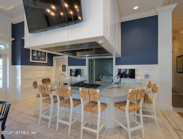 kitchen featuring a kitchen bar, sink, ornamental molding, kitchen peninsula, and decorative backsplash