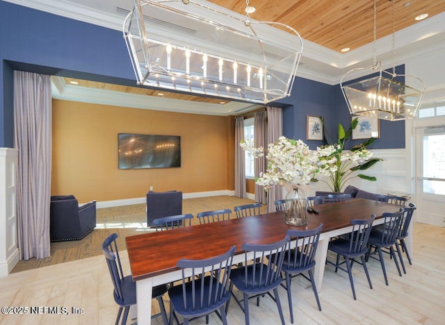 dining space with ornamental molding, wooden ceiling, light wood-type flooring, and a tray ceiling