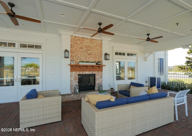 view of patio / terrace featuring an outdoor living space with a fireplace, ceiling fan, and french doors