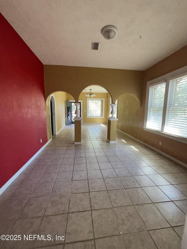 tiled spare room with a textured ceiling