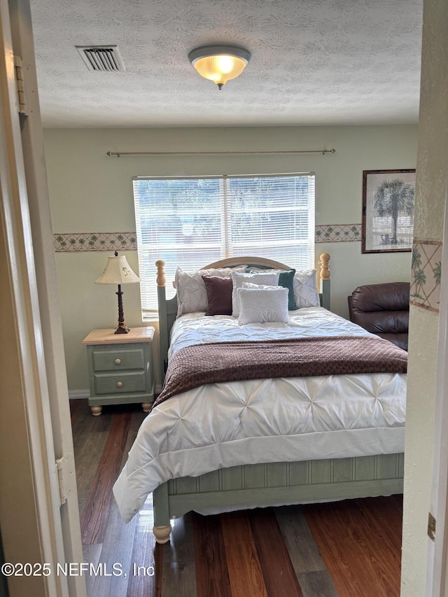 bedroom featuring dark hardwood / wood-style floors and a textured ceiling