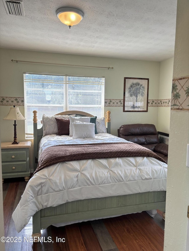 bedroom with dark wood-type flooring and a textured ceiling