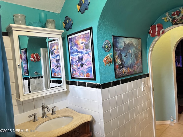 bathroom featuring vanity, tile patterned flooring, and tile walls