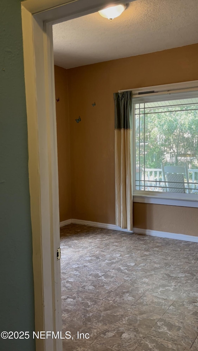 unfurnished room featuring a textured ceiling