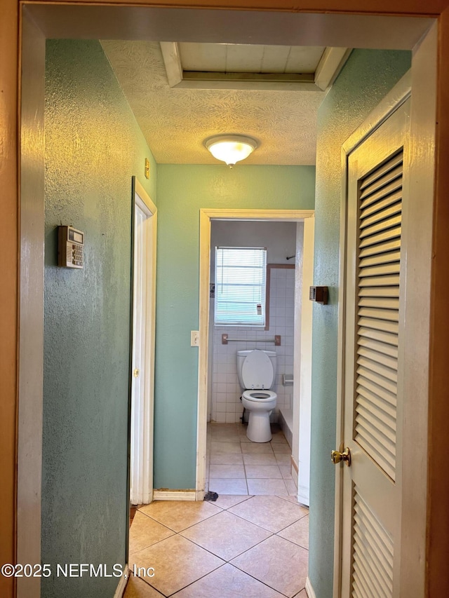 bathroom featuring tile patterned flooring, a textured ceiling, and toilet