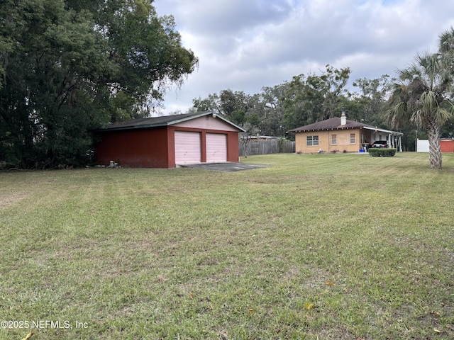 view of yard featuring a garage and an outbuilding