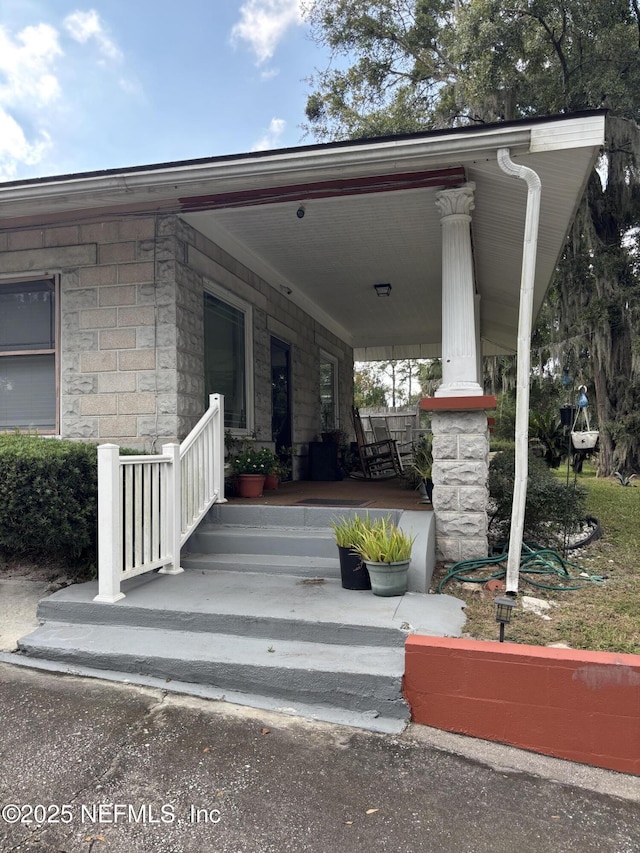 view of exterior entry featuring covered porch