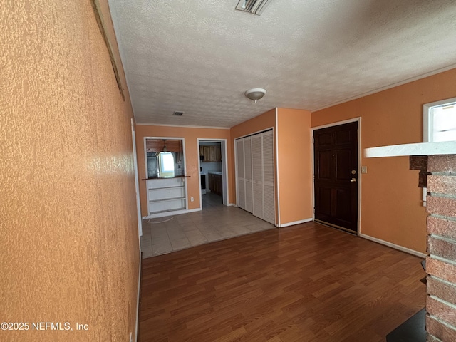 empty room featuring wood-type flooring and a textured ceiling