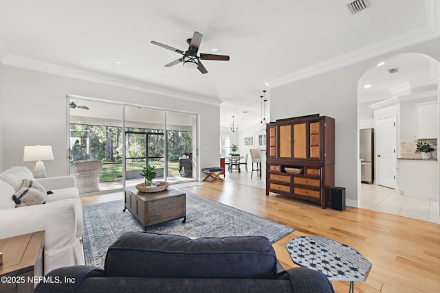 living room with ceiling fan, ornamental molding, a healthy amount of sunlight, and light hardwood / wood-style flooring