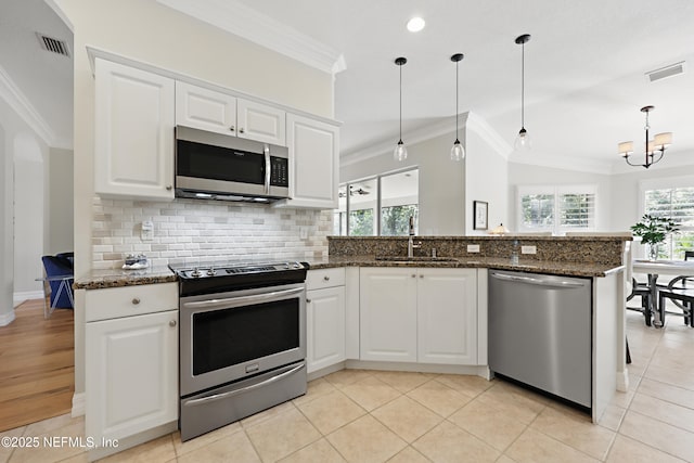 kitchen featuring white cabinetry, stainless steel appliances, sink, and pendant lighting