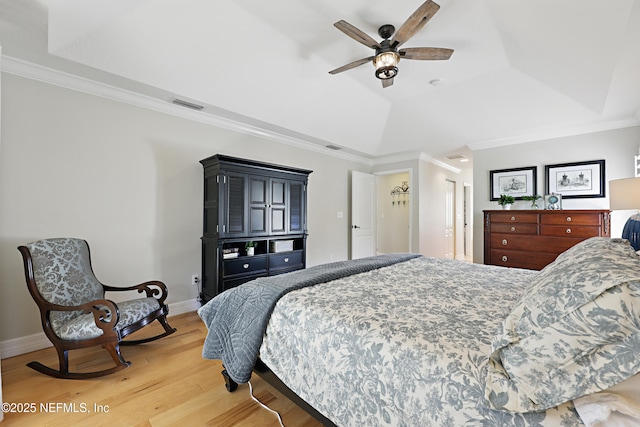 bedroom with lofted ceiling, ornamental molding, a raised ceiling, and hardwood / wood-style floors