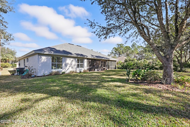 back of house featuring a sunroom and a lawn