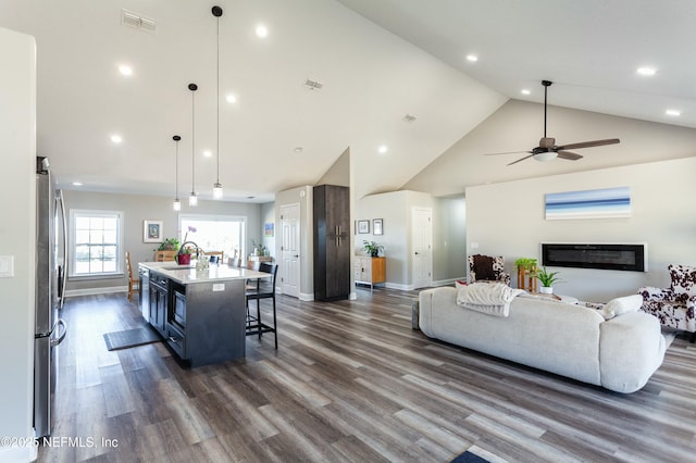 living room featuring ceiling fan, dark hardwood / wood-style flooring, and high vaulted ceiling