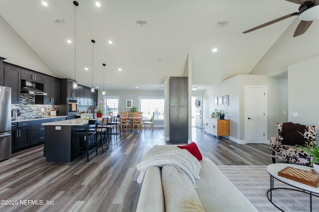 living room with sink, high vaulted ceiling, dark hardwood / wood-style floors, and ceiling fan