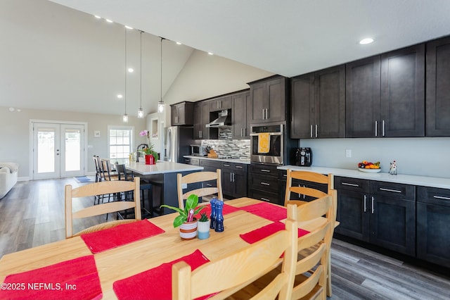 kitchen featuring stainless steel appliances, tasteful backsplash, a kitchen island, decorative light fixtures, and french doors