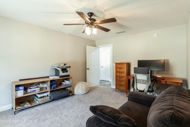 carpeted living room featuring a textured ceiling and ceiling fan