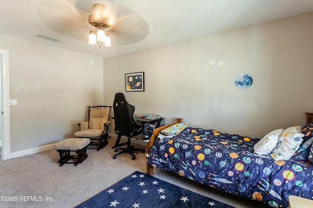 bedroom featuring ceiling fan, carpet floors, and a textured ceiling