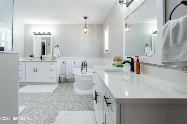 bathroom featuring tile patterned flooring, a bathing tub, vanity, and a chandelier