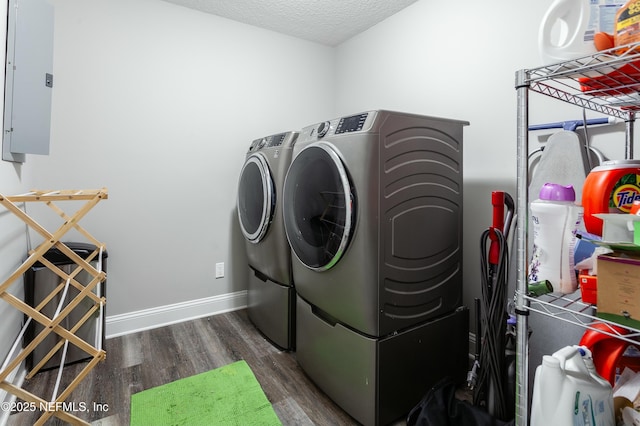 laundry room featuring dark hardwood / wood-style flooring, electric panel, independent washer and dryer, and a textured ceiling