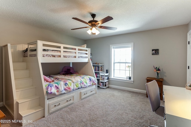 bedroom with ceiling fan, carpet, and a textured ceiling