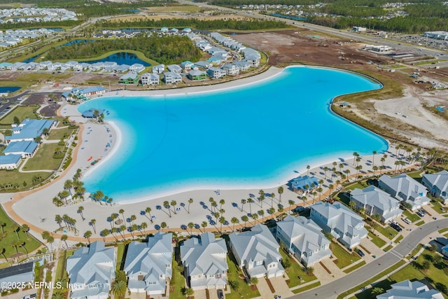 drone / aerial view featuring a water view and a view of the beach