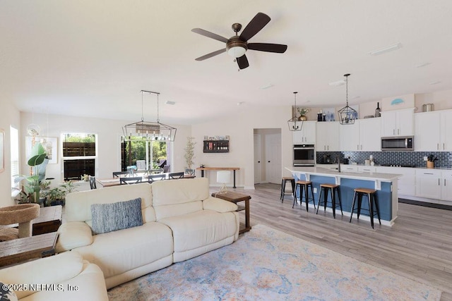 living room featuring light hardwood / wood-style floors and ceiling fan