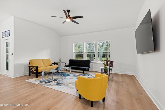 living room featuring light wood-type flooring, baseboards, and lofted ceiling