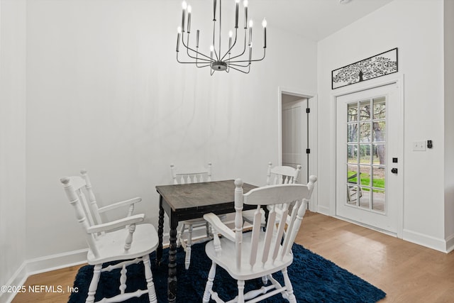 dining space featuring an inviting chandelier, baseboards, and wood finished floors