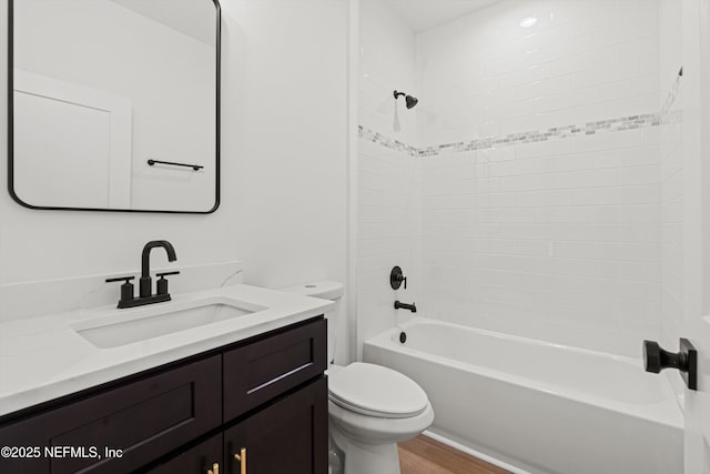 bathroom featuring toilet, shower / bathing tub combination, wood finished floors, and vanity