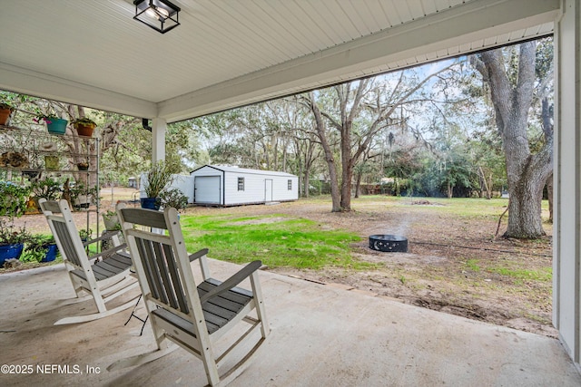 view of patio / terrace featuring a fire pit and an outdoor structure