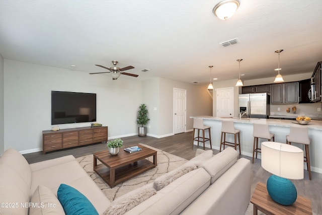 living room with ceiling fan and light wood-type flooring