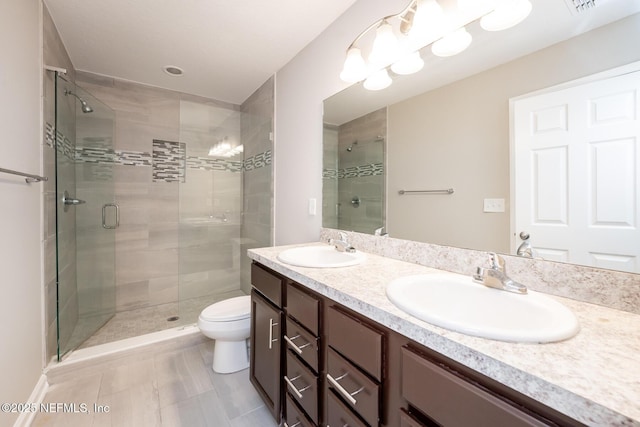 bathroom with vanity, tile patterned floors, a shower with door, and toilet