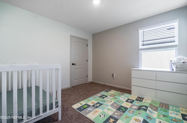 bedroom featuring a crib and dark carpet