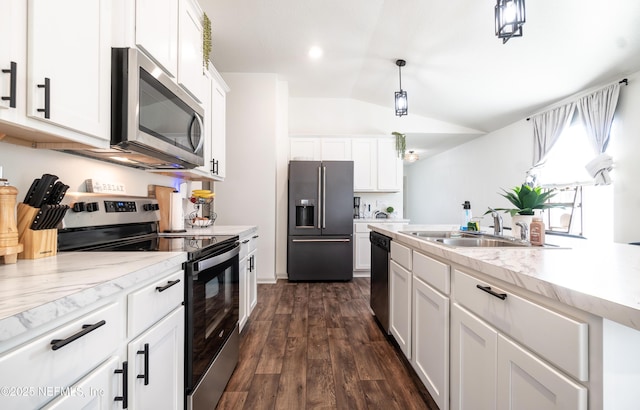 kitchen featuring lofted ceiling, sink, pendant lighting, stainless steel appliances, and white cabinets