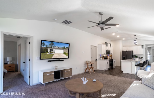 carpeted living room with vaulted ceiling and ceiling fan