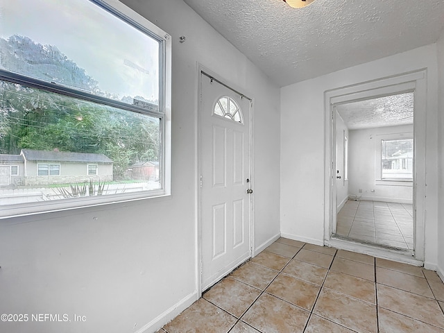 tiled entrance foyer featuring a textured ceiling